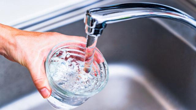 A glass of water being filled in a sink